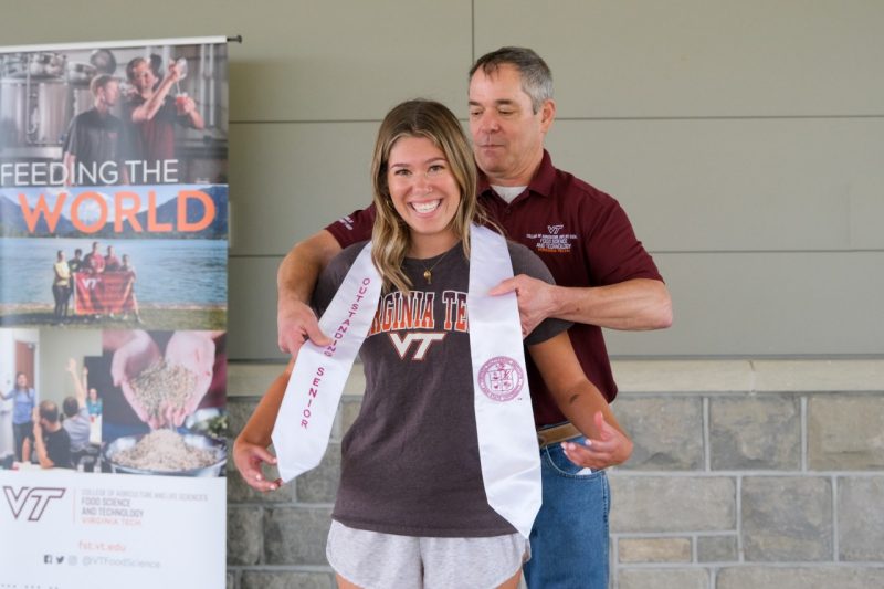 McKenna Helder is presented with her Outstanding Senior award and sash by Dr. Herbert Bruce