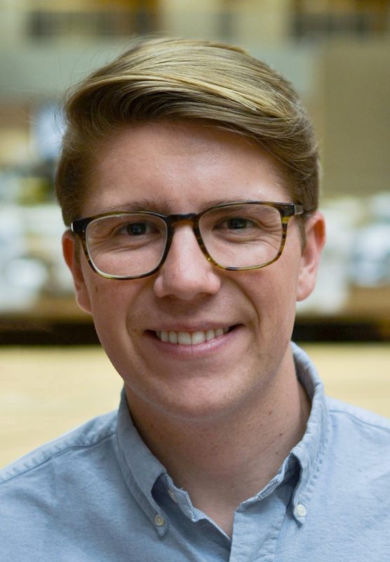 Portrait shot of a young man with blond hair and glasses.