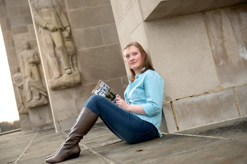 Student reads the 2016-17 common book choice at the War Memorial Pylons