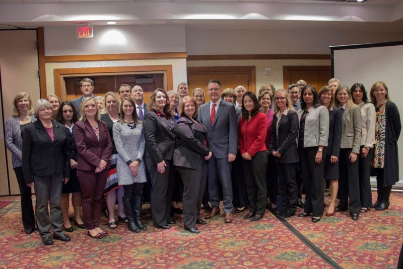 Graduates of the leadership development programs stand with President Tim Sands.