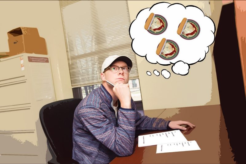 Michael Hanson sits at a desk, taking a test. A cartoon thought bubble is above him with graphics of chicken parmesan. 