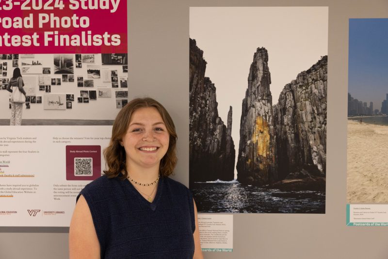 Emma Lucier posing next to her photo at the photo gallery